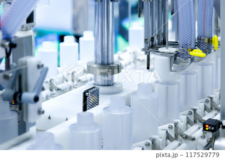 robot arm moving plastic bottle to conveyor belt of auto capping and labeling machine at cosmetic and skin care manufacturing. cosmetic industry and ai technology machinery concept. robot arm moving plastic bottle to conveyor belt of auto capping and labeling machine at cosmetic and skin care manufacturing. cosmetic industry and ai technology machinery concept. 117529779