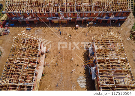 New house under construction, wooden truss system forming roof. Process of building project. New house under construction, wooden truss system forming roof. Process of building project. 117530504