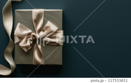 Gift box with golden ribbon. Top view with copyspace template. Christmas holiday mockup. Xmas present for greeting and celebration. Festive decoration on dark background 117533651