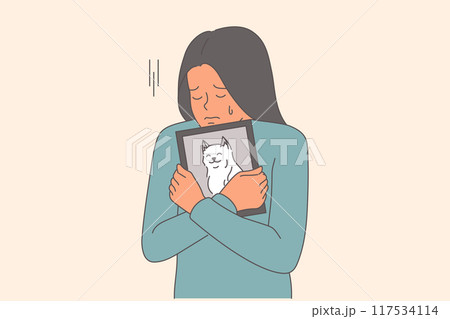Woman cries after dog death and clutches photo of beloved puppy to chest in frustration 117534114