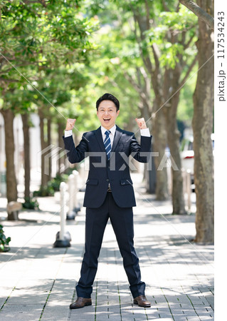 並木道に立つビジネスマン ガッツポーズ 並木道に立つビジネスマン ガッツポーズ 117534243