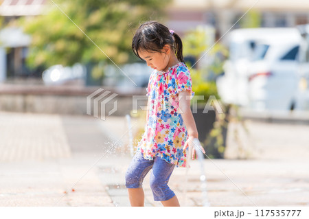 夏の広場の噴水で水遊びをする女の子 夏の広場の噴水で水遊びをする女の子 117535777