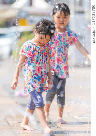 夏の広場の噴水で水遊びをする女の子 夏の広場の噴水で水遊びをする女の子 117535780