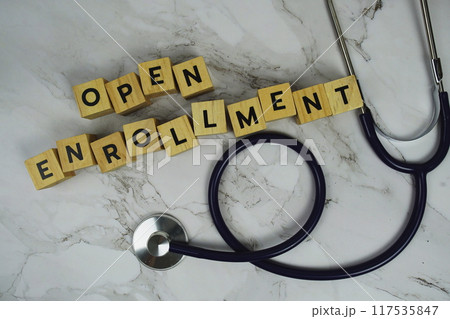 Open Enrollment with wooden blocks alphabet letters and stethoscope on marble background Open Enrollment with wooden blocks alphabet letters and stethoscope on marble background 117535847