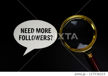Need more Followers? text on speech bluble with magnifying glass top view on black background 117536223