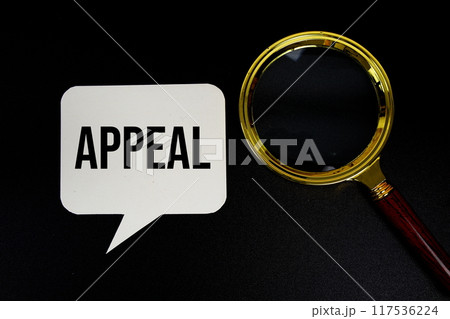 Appeal text on speech bluble with magnifying glass top view on black background 117536224