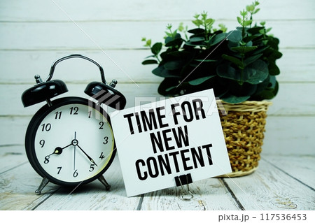 Time For New Content text on paper card with alarm clock on wooden background 117536453