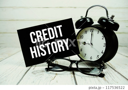 Credit History text on paper card with alarm clock on wooden background 117536522