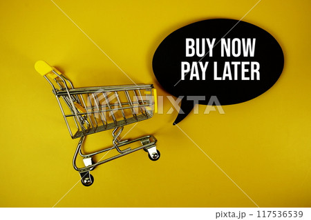 Buy Now Pay Later text on speech bubble with mini trolley shopping cart top view on yellow background 117536539