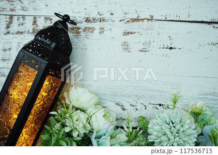 Black Moroccan Arabic lantern with flower on white table background 117536715
