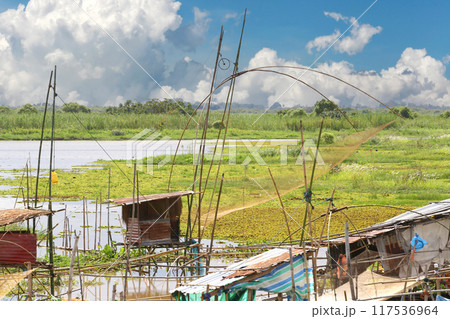 Local fishermen's riverside huts and nets for catching fish. Local fishermen's riverside huts and nets for catching fish. 117536964