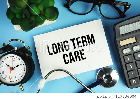 Long term care text with calculator, magnifying glass and alarm clock on blue background 117536984