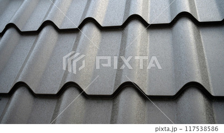 Close-up view lightweight galvanised steel roofing sheet. Modular tile effect roof panel. Traditional metal shingle tiles. Popular profiled metallic pantile mimic clay or concrete slate Close-up view lightweight galvanised steel roofing sheet. Modular tile effect roof panel. Traditional metal shingle tiles. Popular profiled metallic pantile mimic clay or concrete slate 117538586