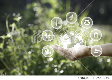 green energy concept. Global warming icons set on hands with nature green background. Net zero 2050 green energy icon around Carbon Neutral in industry. Net zero emissions concept. innovation idea. green energy concept. Global warming icons set on hands with nature green background. Net zero 2050 green energy icon around Carbon Neutral in industry. Net zero emissions concept. innovation idea. 117539239
