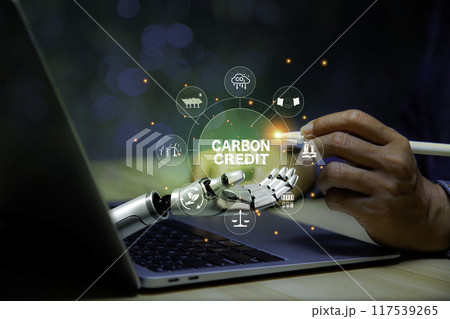 Businessman points at carbon credit icon in in robotic hand Green energy icon around it. Green Energy Renewable Sustainable concept. Net zero emission Idea innovative.carbon neutrality in 2050. Businessman points at carbon credit icon in in robotic hand Green energy icon around it. Green Energy Renewable Sustainable concept. Net zero emission Idea innovative.carbon neutrality in 2050. 117539265