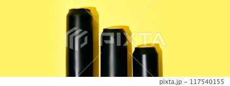 Black aluminum cans placed on bright yellow background. Mockup. Banner. Beer, lemonade, soda water, energy drinks 117540155