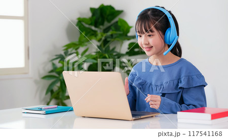 ヘッドホンをつけてノートパソコンで勉強する女の子 117541168