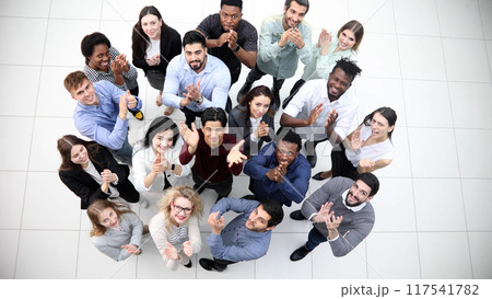 Diverse group of happy young people looking up and smiling at camera. Diverse group of happy young people looking up and smiling at camera. 117541782