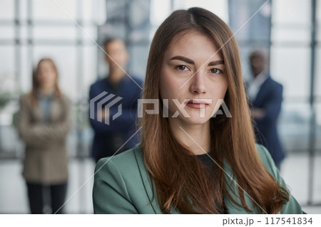 Portrait of a confident young businesswoman standing with her arms crossed in an office Portrait of a confident young businesswoman standing with her arms crossed in an office 117541834