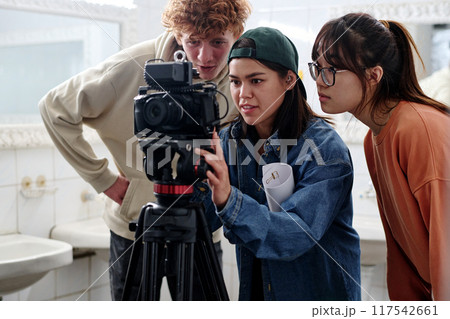 Filming Scene with Focused Team Members and Camera Filming Scene with Focused Team Members and Camera 117542661