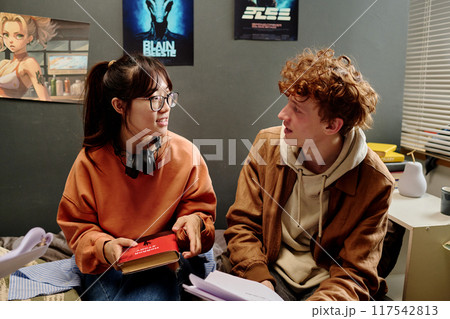 Conversing About Study Material in Cozy Bedroom Setting 117542813