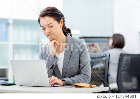 パソコンの画面を見ながら悩むビジネスウーマン パソコンの画面を見ながら悩むビジネスウーマン 117544081