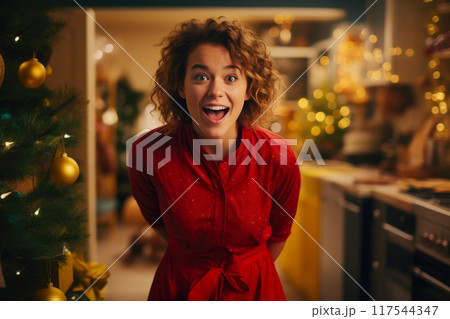 Cheerful Woman Adding Sparkle to Christmas Tree 117544347