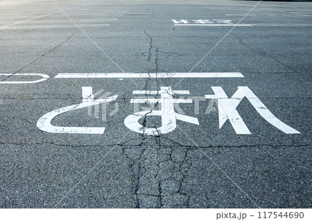 駐車場の路面に書かれたとまれの文字 117544690