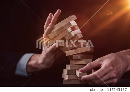 Plan and strategy in business, Risk To Make Business Growth Concept With Wooden Blocks, hand of man has piling up and stacking a wooden block. Plan and strategy in business, Risk To Make Business Growth Concept With Wooden Blocks, hand of man has piling up and stacking a wooden block. 117545187