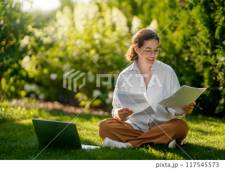 woman working on laptop in summer morning 117545573