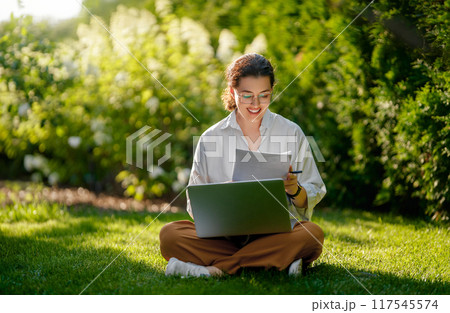 woman working on laptop in summer morning 117545574