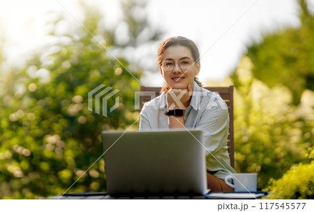 woman working on laptop in summer morning 117545577