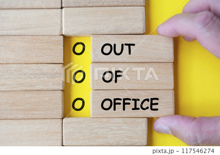 Hand pulling wooden blocks with Out Of Office. Out of office concept. 117546274