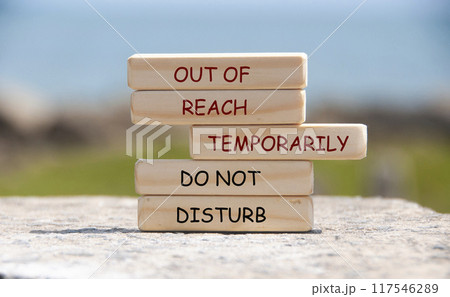 Out of Reach Temporarily. Do not disturb text on wooden blocks with blurred nature background. Out of office concept. 117546289