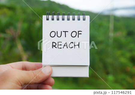 Out of Reach text on white notepad with nature background. Out of office concept. 117546291