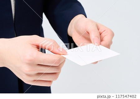 名刺を渡すスーツ姿の女性の手元 117547402