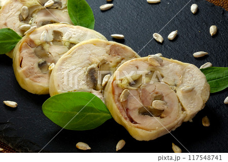 Meat Roll Slices Garnished With Spinach and Sunflower Seeds on a Black Ceramic Board Meat Roll Slices Garnished With Spinach and Sunflower Seeds on a Black Ceramic Board 117548741