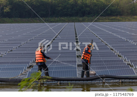 Worker Cleaning floating solar panels or solar cell Platform system on the lake Worker Cleaning floating solar panels or solar cell Platform system on the lake 117548769