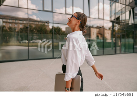 A Confident Businesswoman is Walking with Purpose in a Modern Urban Setting Today 117549681