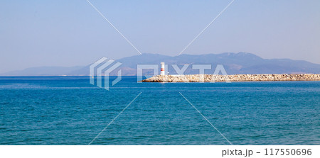 Lighthouse in the bay of Kusadasi. Lighthouse in the blue sea on a clear sunny day. 117550696