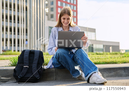 Young female college student using laptop computer outdoor 117550943