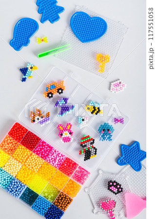 Children's toys made of aqua beads and a set for making on the table top and vertical view 117551058