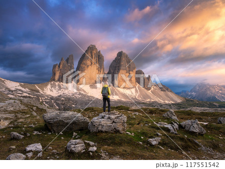 Girl with backpack on the stone and high mountain peaks at sunse Girl with backpack on the stone and high mountain peaks at sunse 117551542