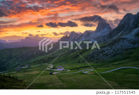 Road in mountains, golden sunlight and colorful sky at sunset 117551545