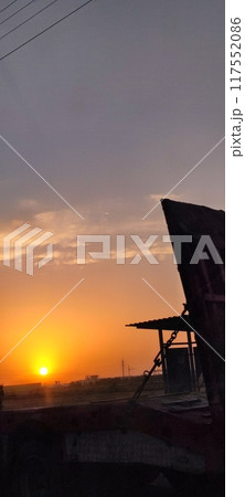 A sunset descends over a serene beach with a lifeguard tower 117552086