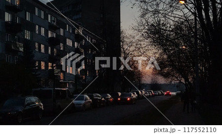 Several cars are parked alongside the building during the night hours 117552110