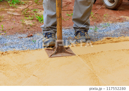 Sand tamping with worker uses manual rammer 117552280