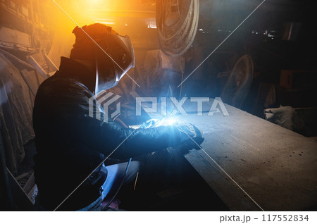 craftsman works in his old garage on an order, metal welding 117552834