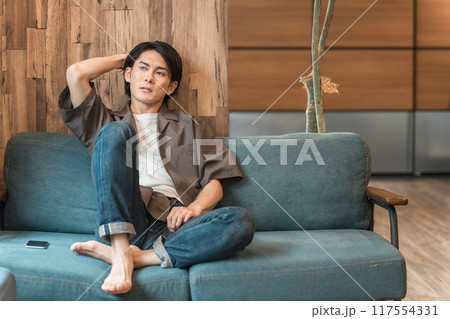 家のリビングで退屈な時間を過ごす若いアジア人男性(つまらない・憂鬱・無気力・ダルい・疲労・鬱病) 家のリビングで退屈な時間を過ごす若いアジア人男性(つまらない・憂鬱・無気力・ダルい・疲労・鬱病) 117554331