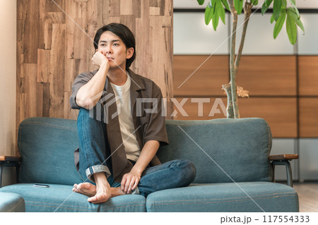 家のリビングで退屈な時間を過ごす若いアジア人男性(つまらない・憂鬱・無気力・ダルい・疲労・怒る) 家のリビングで退屈な時間を過ごす若いアジア人男性(つまらない・憂鬱・無気力・ダルい・疲労・怒る) 117554333